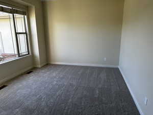 Carpeted empty room with plenty of natural light and baseboards