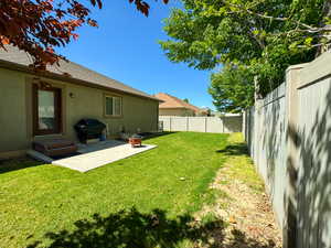 View of yard featuring a fenced backyard and a patio