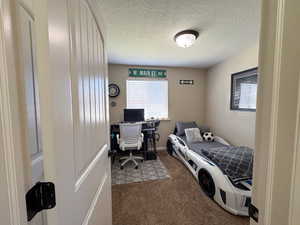 Carpeted bedroom featuring a textured ceiling