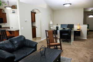 Office space featuring light colored carpet, baseboards, and arched walkways