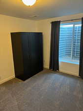 Unfurnished bedroom with carpet and baseboards