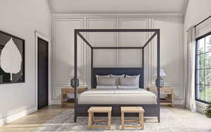 Bedroom with crown molding, baseboards, light wood-style flooring, and a decorative wall