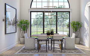 Dining room featuring baseboards, wood finished floors, and a chandelier