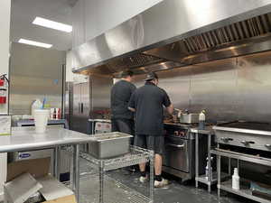 Kitchen with wall chimney exhaust hood and concrete floors