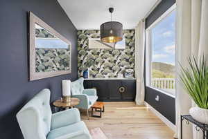 Living area with plenty of natural light, light wood-type flooring, and baseboards