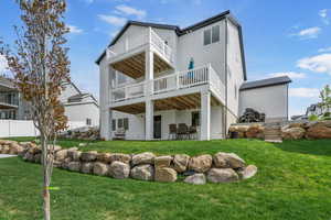 Back of house with a balcony and a patio