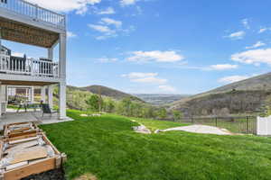 View of yard with a mountain view, a patio area, and a balcony