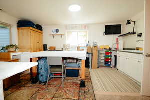 Kitchen featuring open shelves, a sink, white cabinetry, and light colored carpet