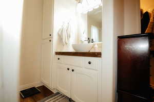 Bathroom featuring vanity, wood finished floors, and baseboards