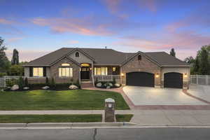 View of front facade featuring an attached garage, brick siding, a porch, and driveway