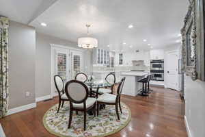 Dining area featuring recessed lighting, a chandelier, baseboards, dark wood-style flooring, and french doors