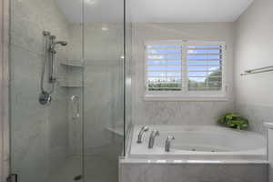 Full bath featuring a marble finish shower and a tub with jets