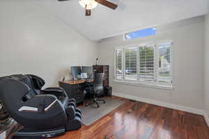 Office area featuring a ceiling fan, wood finished floors, baseboards, and vaulted ceiling