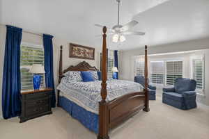 Bedroom with light carpet, a ceiling fan, and baseboards