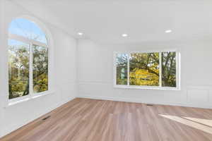 Unfurnished room featuring a healthy amount of sunlight, light wood-style flooring, visible vents, and recessed lighting