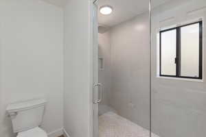 Full bathroom with toilet and a shower stall