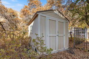 View of shed featuring fence