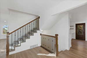 Stairs featuring baseboards, visible vents, and wood finished floors