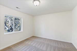 Unfurnished room with light colored carpet, visible vents, and baseboards