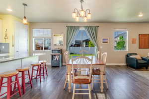 Dining area with healthy amount of natural light, baseboards, dark wood-style floors, and recessed lighting