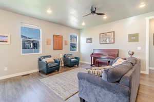 Living room featuring ceiling fan, wood finished floors, baseboards, and recessed lighting