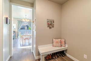 Mudroom with a chandelier, wood finished floors, and baseboards