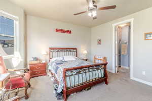 Carpeted bedroom featuring baseboards and a ceiling fan