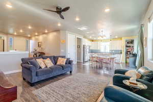 Living area featuring recessed lighting, a ceiling fan, baseboards, dark wood-style flooring, and a chandelier