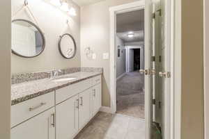 Bathroom featuring vanity, baseboards, and tile patterned floors