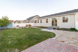 Rear view of house featuring stucco siding, a patio area, an outbuilding, and a storage unit