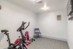 Exercise room featuring wood finished floors and baseboards