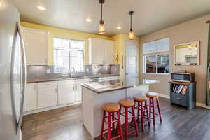 Kitchen featuring stainless steel appliances, a sink, dark wood-type flooring, white cabinetry, and recessed lighting