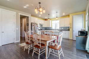 Dining area with a chandelier, dark wood-style floors, recessed lighting, and baseboards