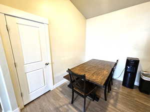 Dining room with wood finished floors, baseboards, and vaulted ceiling