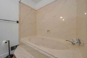 Bathroom featuring a whirlpool tub and a shower