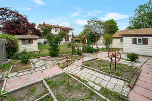 View of grassy yard with a vegetable garden and an outbuilding