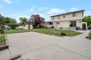 Back of property with a storage shed, a patio area, an outbuilding, and central AC
