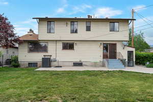 Back of property with a yard, a patio, central AC, and entry steps