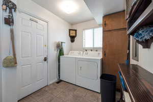 Clothes washing area featuring washer and clothes dryer and light tile patterned floors