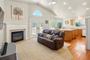 Great room featuring plenty of natural light, lofted ceiling, french doors, recessed lighting, and a ceiling fan