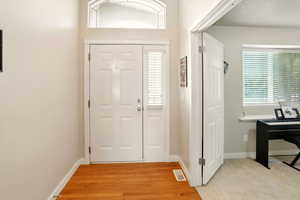 Foyer entrance with baseboards and light wood-type flooring