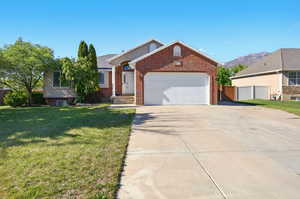 Single story home with brick siding, driveway, an attached garage, RV Parking and a mountain view