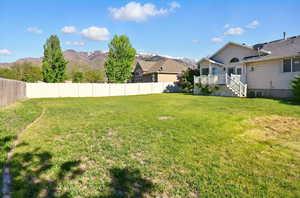 View of yard with a deck with mountain view