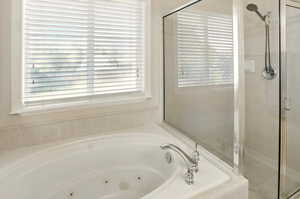 Full bathroom with a tub with jets and a separate shower