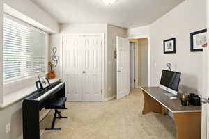 Bedroom or office with light colored carpet and baseboards