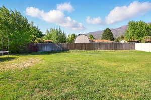 View of yard featuring a trampoline and a mountain view