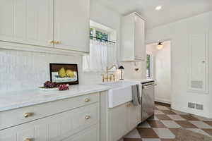 Kitchen with dishwasher, a sink, tile floors, natural light, and brass faucet, farm sink tile backsplash