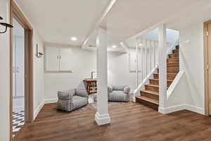 Finished basement featuring baseboards, recessed lighting, wood finished floors, and stairway
