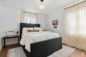 Primary Bedroom with wood finished floors and baseboards