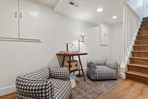 Living area featuring stairway, baseboards, light wood-style floors, and recessed lighting